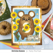 A handmade autumn-themed greeting card featuring a brown mouse holding yellow sunflowers, with the text 'Love fall MOST OF all'. The card is displayed on a light blue surface with craft props and a brand watermark at the bottom.