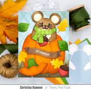 A handmade autumn mouse and pumpkin card displayed on a light wood surface with fall leaves, ribbon, and craft cutouts around it. The card features a stitched mouse wearing a green scarf, sitting on an orange pumpkin with acorns and leaves, and a banner that reads “HEY PUMPKIN.