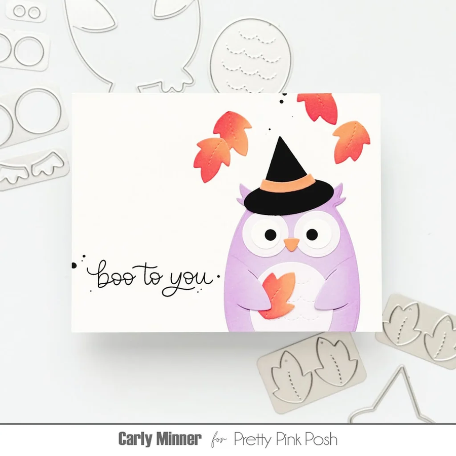 A white handmade greeting card featuring a purple owl wearing a black witch hat with orange leaves, plus the handwritten text 'boo to you'. The card is styled with metal die-cut craft tools on a white background.
