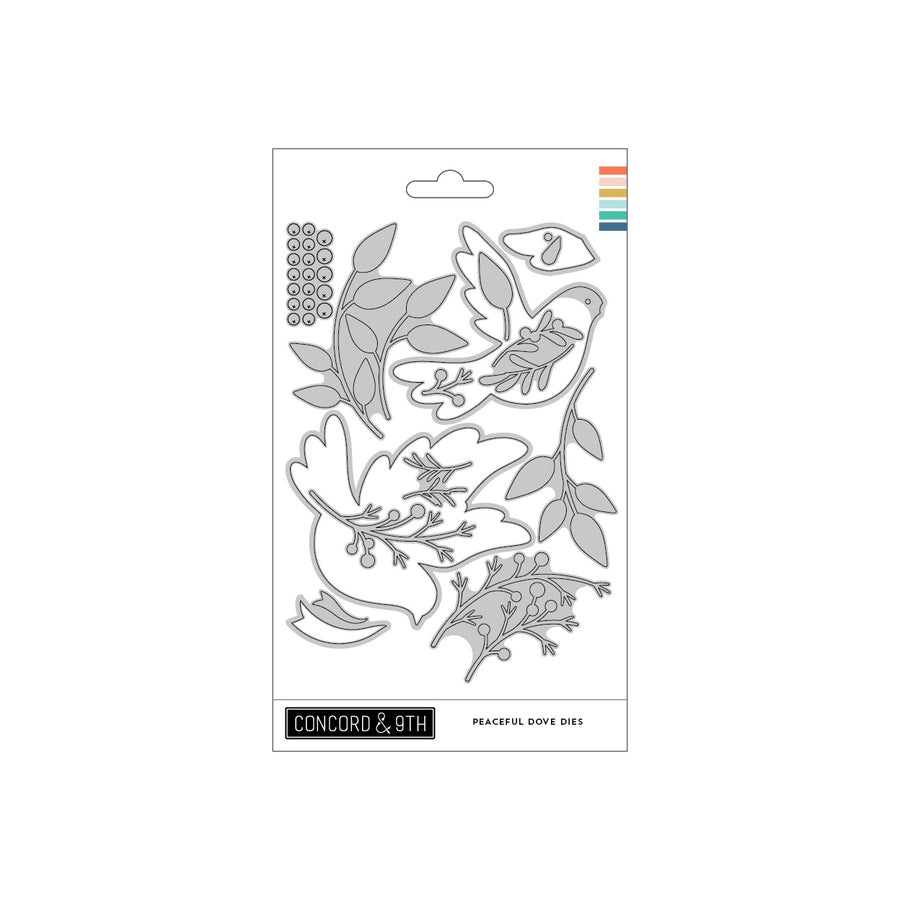 Concord & 9th Peaceful Dove Dies set in its retail packaging, featuring a white card with gray metal die-cut outlines of doves, leaves, and berries, with a small rainbow color strip on the top right.