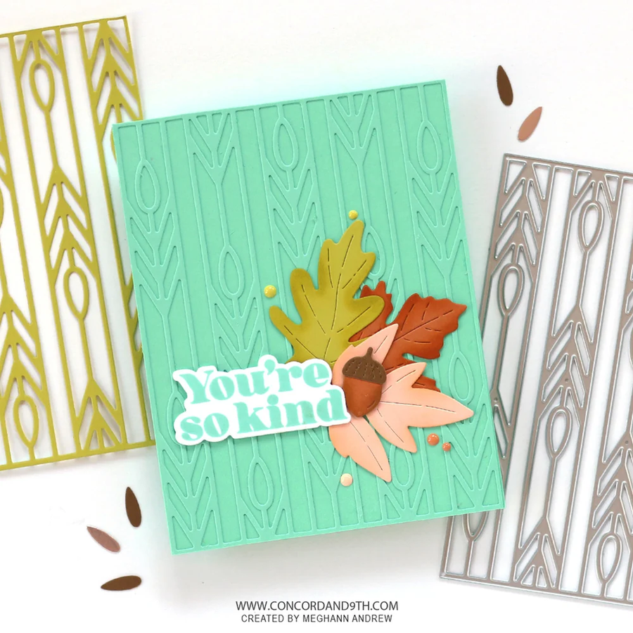 A handmade greeting card with a mint green embossed wheat pattern, decorated with layered autumn leaves, an acorn, and a die-cut sticker that reads 'You're so kind'. Two metal die-cutting mats are partially visible on either side on a white background.