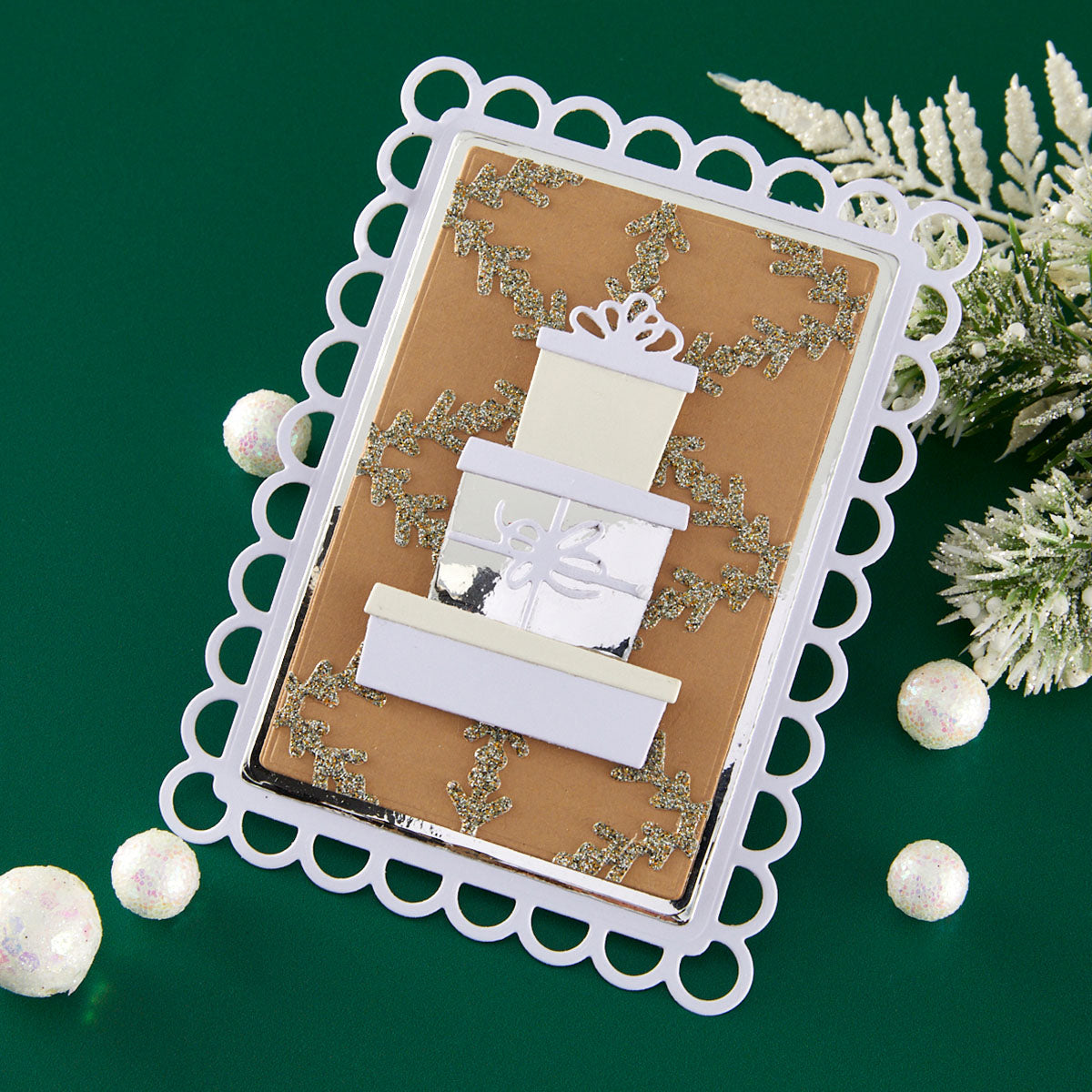 Decorative card with white gift box design on a green background using Spellbinders Gift Boxes and Bags Etched Dies by Lisa Horton