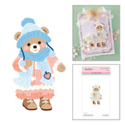 A product collage featuring a cute illustrated teddy bear character wearing a blue knit hat and scarf, a decorated card with the same bear motif, and a package labeled Spellbinders Bundled Up Winter Bear Etched Dies by Frank Garcia on a white background.