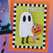 A handmade Halloween greeting card featuring a white ghost holding a jack-o'-lantern, with the text 'HEY GHOUL!' on a lime green background, bordered by a black-and-white check pattern. The card is displayed on an orange backing card with other themed card elements partially visible. Using Spellbinders Color Block Accent Rectangles Die Bundle