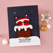 A handmade Christmas greeting card featuring a playful Santa Claus figure emerging from a brick chimney with white snow-like trim, set against a dark navy starry background. The card has a white curved base with the text 'HOPE YOUR Holidays ARE MERRY & BRIGHT.