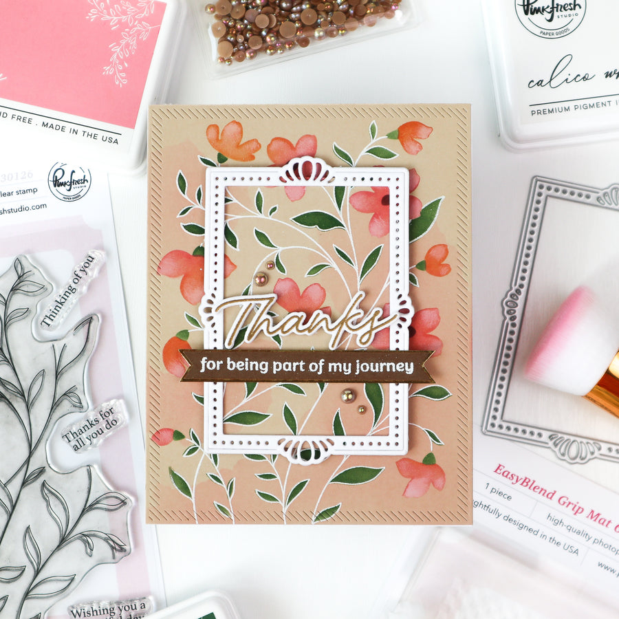 Floral card with 'Thanks for being part of my journey' text on a crafting surface with stamps and tools.