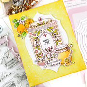 A handmade greeting card featuring a honey jar illustration with the words 'SIMPLE JOYS' and 'shine your rest comfort & healing', surrounded by orange and floral details, displayed on a flat-lay of crafting supplies.