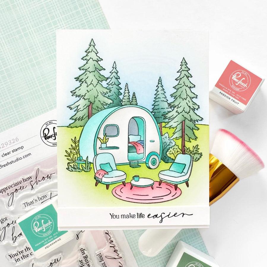 Card with a camper illustration and 'You make life easier' text, surrounded by stamping supplies.