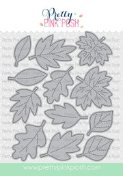 A sheet of die-cut leaf shapes from Pretty Pink Posh, featuring various autumn leaf designs in gray with dashed line details, shown on a white patterned background with the brand logo at the top. Pretty Pink Posh Stitched Leaves Dies
