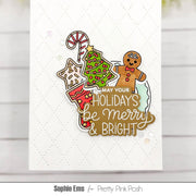 A handmade holiday greeting card featuring a layered die-cut design with a green Christmas tree, candy cane, gingerbread man, stocking, and the phrase “MAY YOUR HOLIDAYS be Merry & BRIGHT,” shown on a white embossed cardstock background.