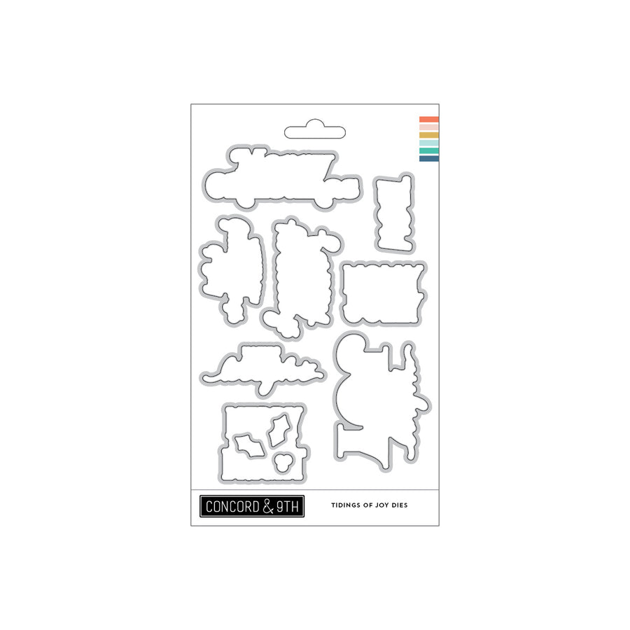A package of Concord & 9th 'Tidings of Joy Dies' metal cutting dies, featuring various holiday-themed die shapes on a white backing card with a colorful brand stripe.