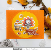 A handmade Thanksgiving-themed card featuring a cartoon turkey, pumpkins, acorns, and the words 'many thanks' on an orange background, styled with autumn leaves and decorative elements. Text at the bottom reads 'Debbie Frank for Pretty Pink Posh'.