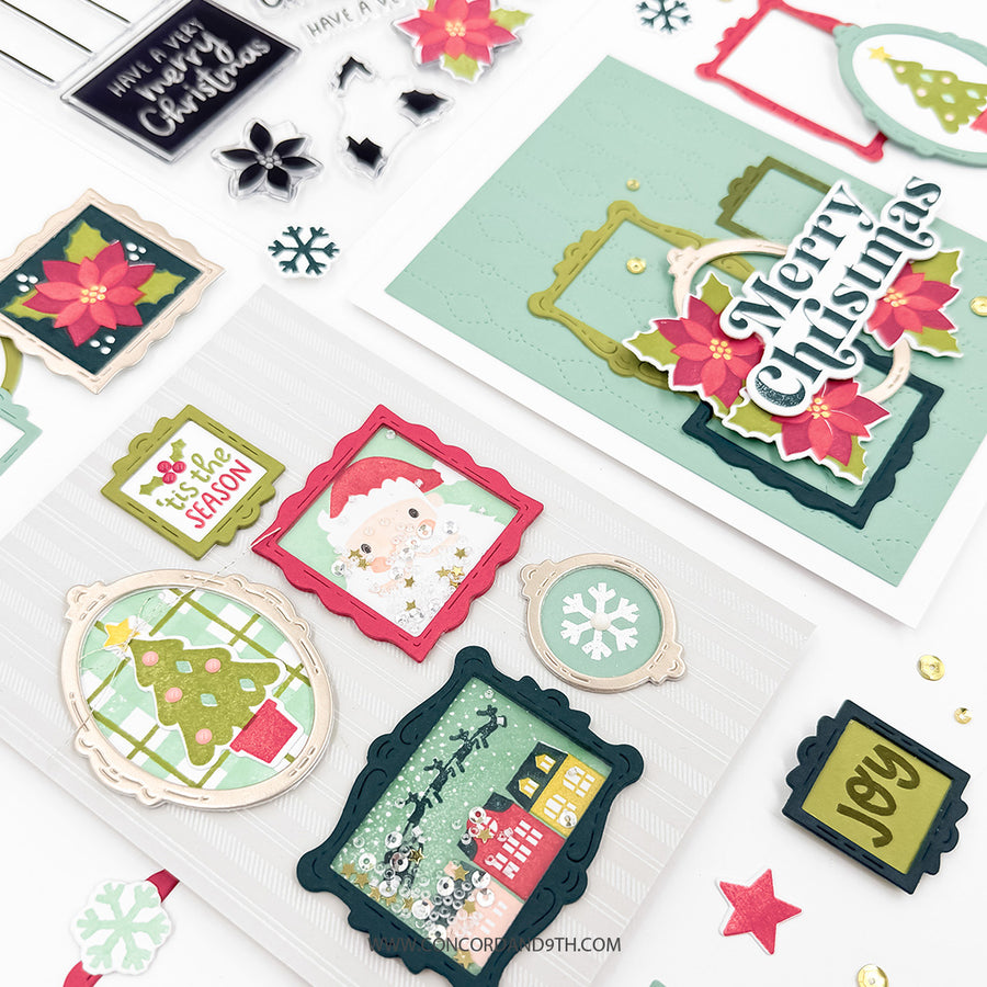 A styled flat-lay of Christmas-themed crafting supplies and cards on a white background, including layered holiday cards, scalloped die-cut frames, snowflake and star embellishments, and a small Santa card.