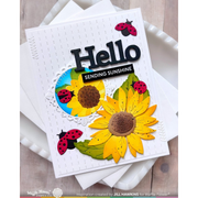 A handmade greeting card featuring yellow sunflowers, green leaves, ladybugs, and the text 'Hello Sending Sunshine' on a white card, styled on top of white envelopes over a light wood surface.