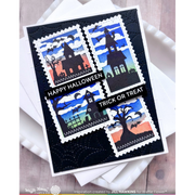 A handmade Halloween greeting card featuring four postage-stamp-like panels with haunted-house illustrations in blue, black, white, green, and orange. The card reads “HAPPY HALLOWEEN” and “TRICK OR TREAT,” photographed on stacked white envelopes over a light wood surface.