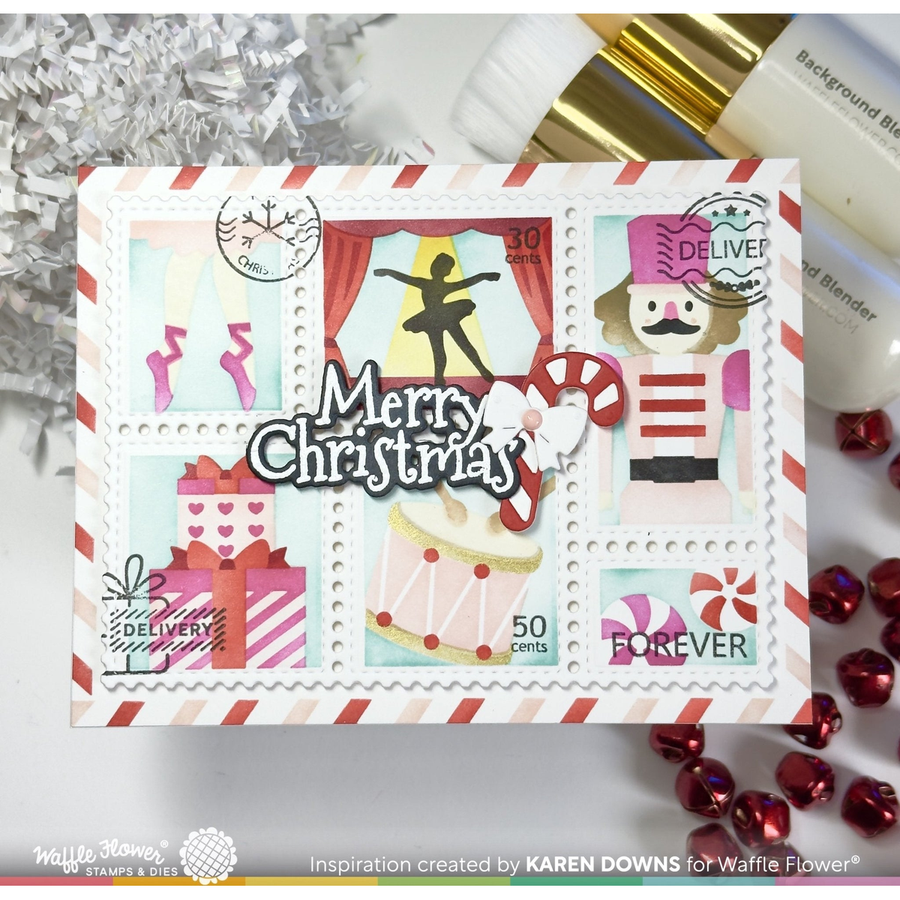 A handmade Christmas stamp-style greeting card featuring festive illustrations including a nutcracker, gifts, candy canes, and the text 'Merry Christmas' and 'Delivery Forever.' The card is styled on a white surface with holiday tinsel, red beads, and cosmetic bottles in the background.