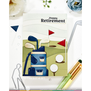 A handmade A6 card featuring a golf-themed retirement design with the words 'Happy Retirement' at the top, shown on a white flat-lay background with decorative flowers, metal cutout outlines, and golf props.