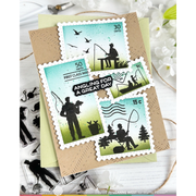 A handmade greeting card featuring four postage stamp designs with black silhouettes of anglers fishing, birds, and trees, set on a kraft paper background with decorative props.