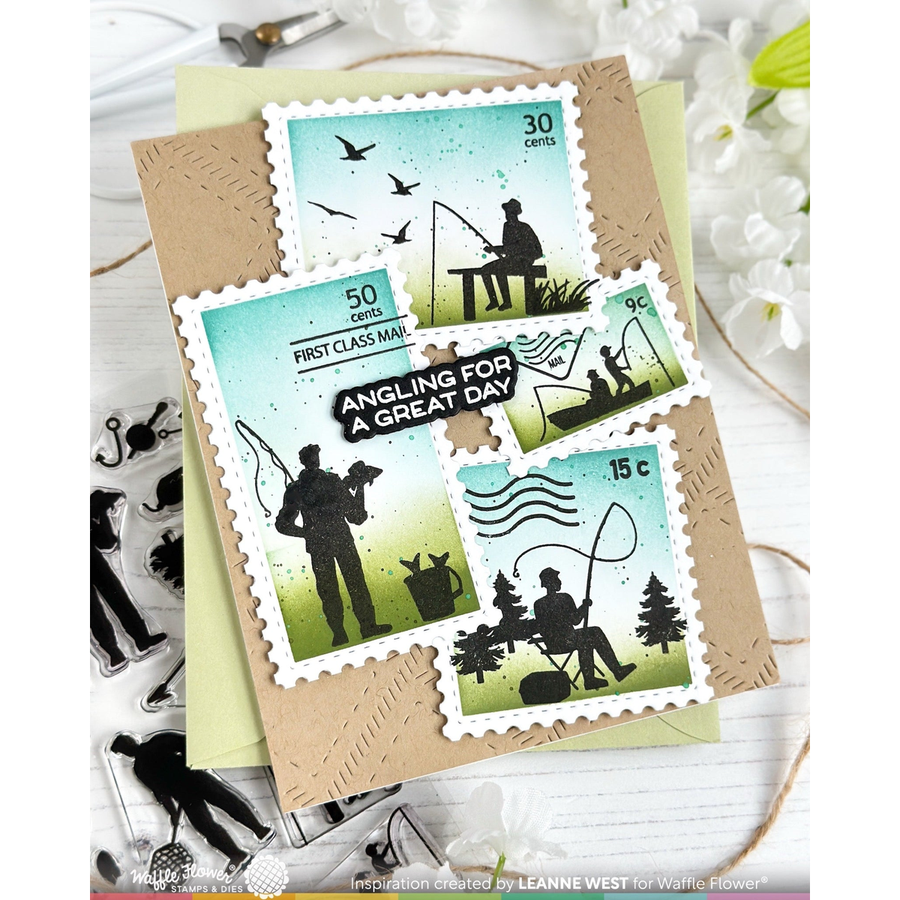 A handmade greeting card featuring four postage stamp designs with black silhouettes of anglers fishing, birds, and trees, set on a kraft paper background with decorative props.