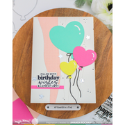 A handmade greeting card with three heart-shaped balloons in mint green, pink, and yellow, displayed on a round wooden board. The card features the text 'FILLED WITH birthday wishes & LONG OF LOVE' and is branded with Hello Stamp.