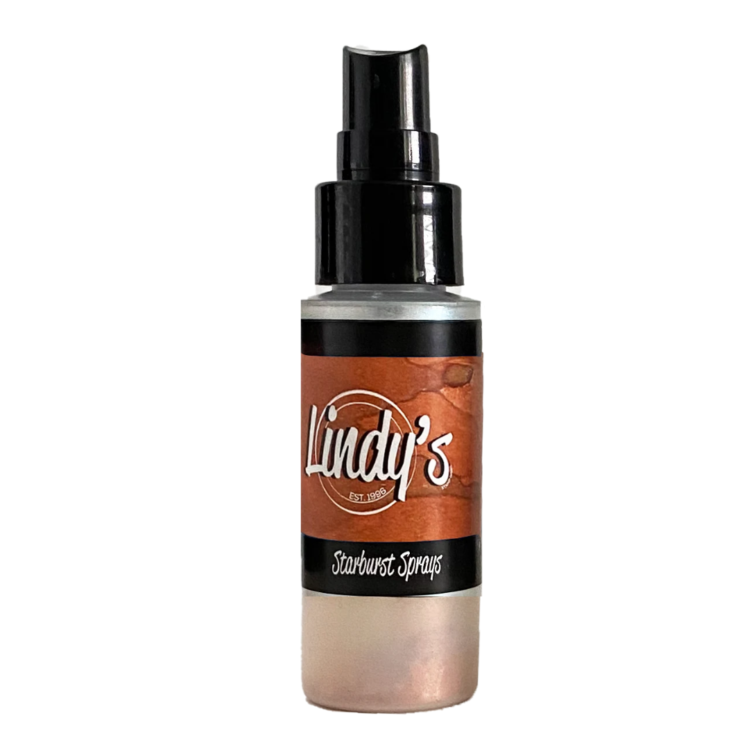 A bottle of Lindy's Starburst Sprays with a black spray nozzle and a label showing a coppery orange and metallic rose gold color, on a plain white background. Lindy's Gang Canna Lily Burnt Orange Starburst Spray