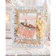 A handmade layered Christmas card featuring a drum illustration, the text 'DRUMROLL! FOR CHRISTMAS', snowflake cutouts, ribbon, and decorative embellishments, photographed in a softly lit holiday setting.